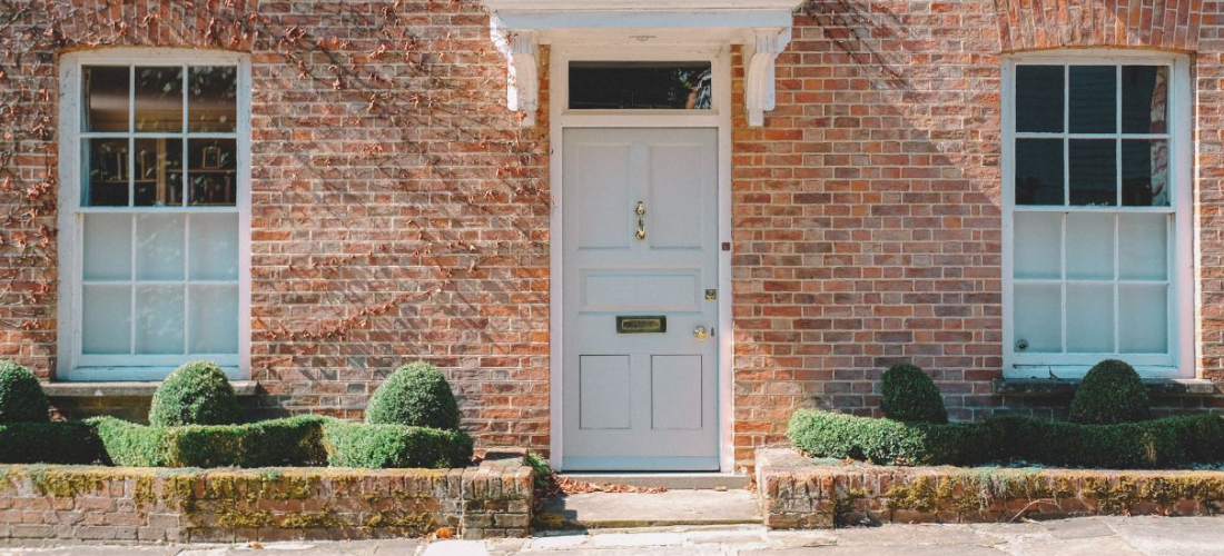 A UK house with shrubs outside and a fancy front door