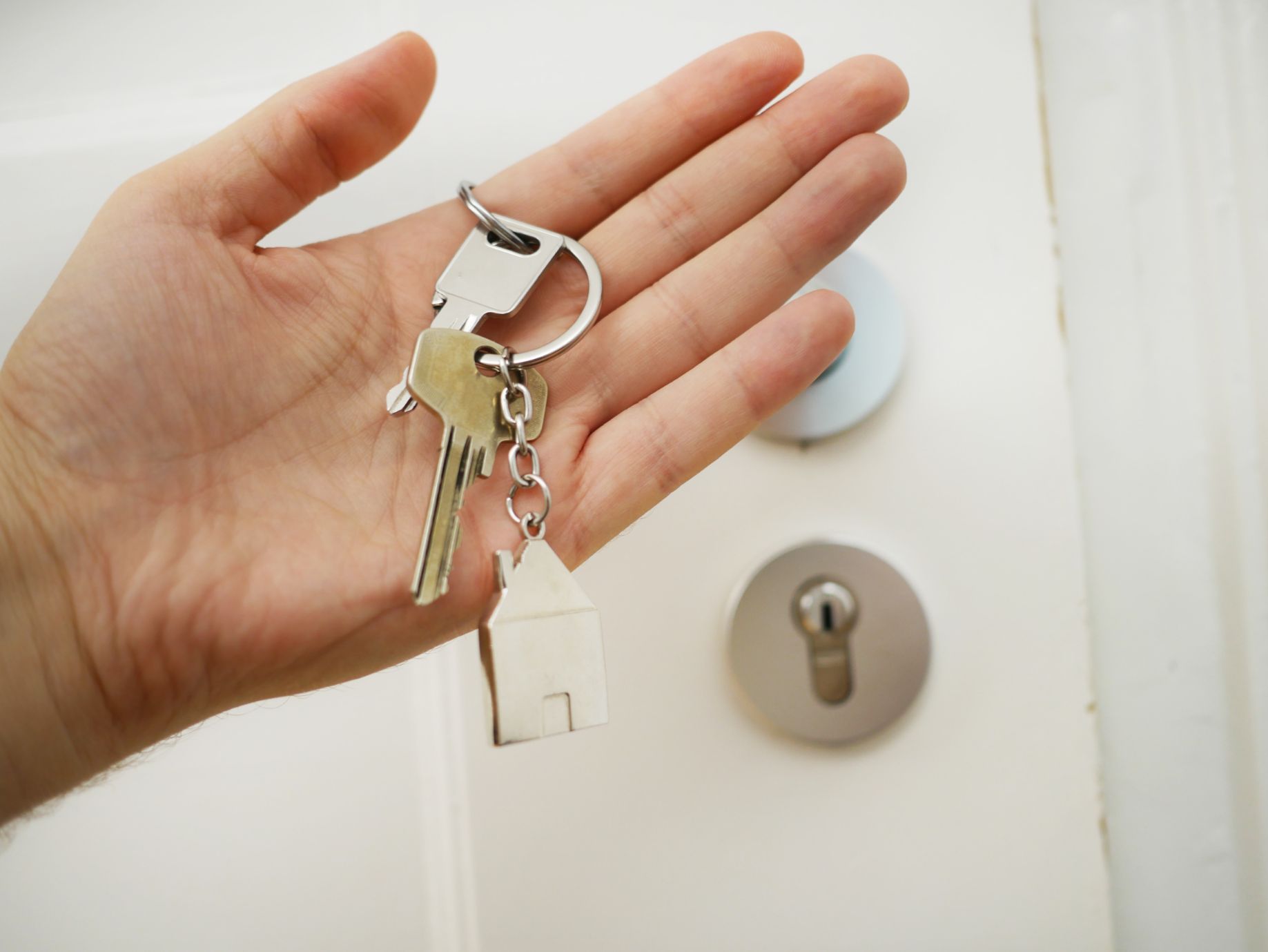 A new homeowner holding up a pair of keys to their house