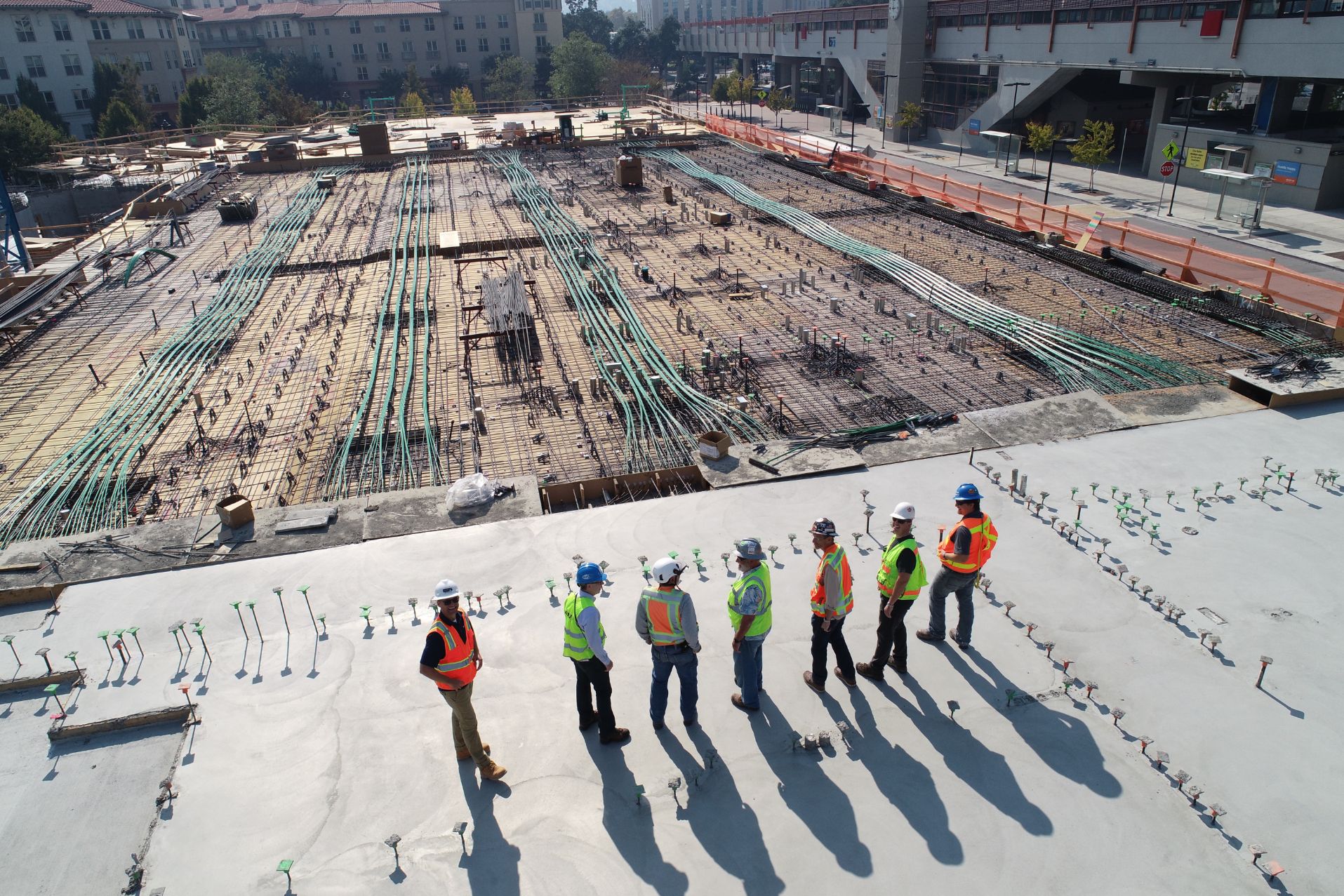 Builders in a row looking at a large construction site