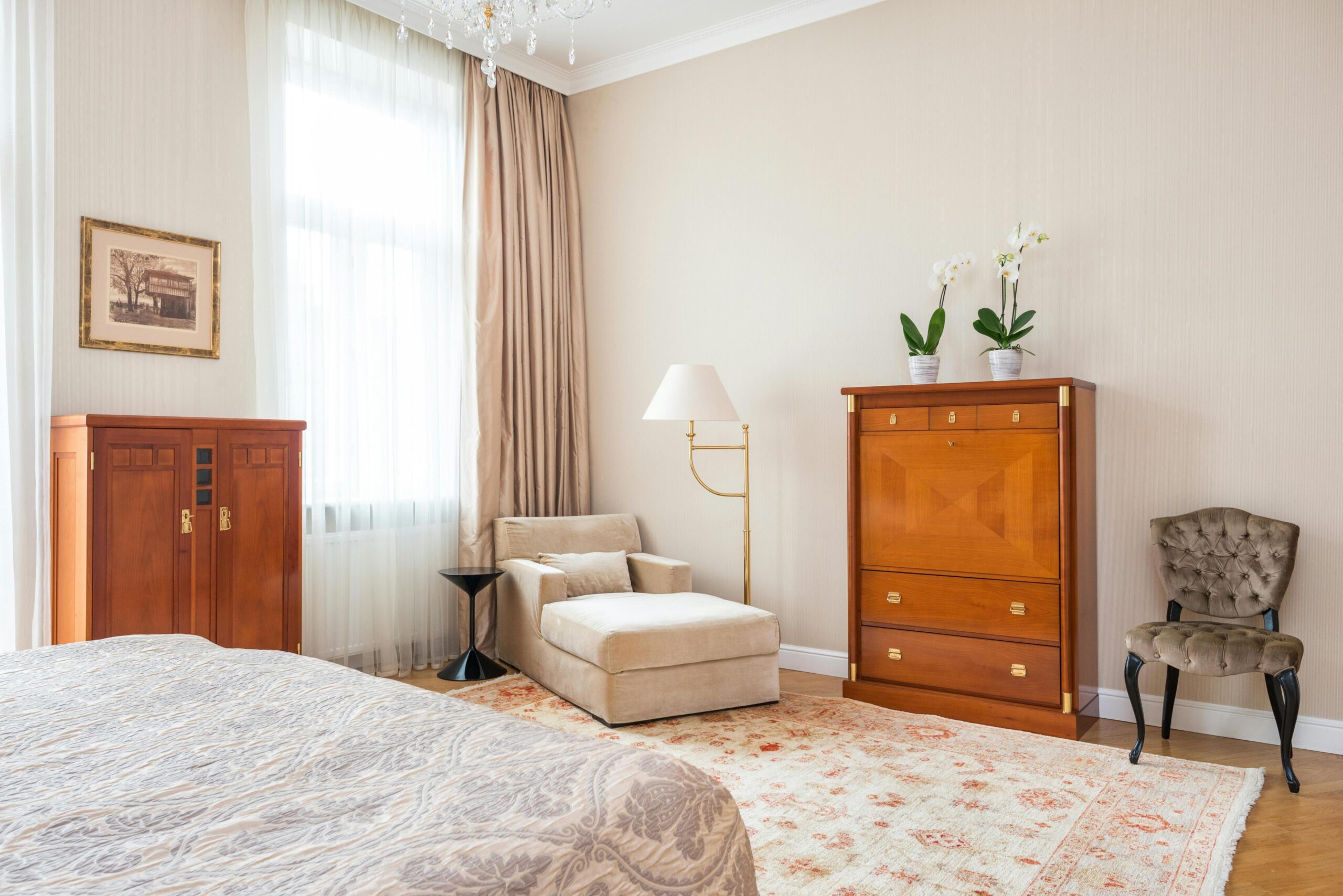 A beautiful bedroom with wooden flooring and a rug with antique furniture