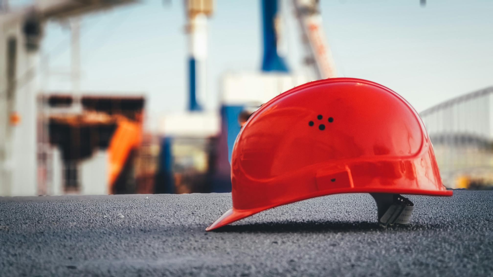 An orange hard hat on the ground of a construction site