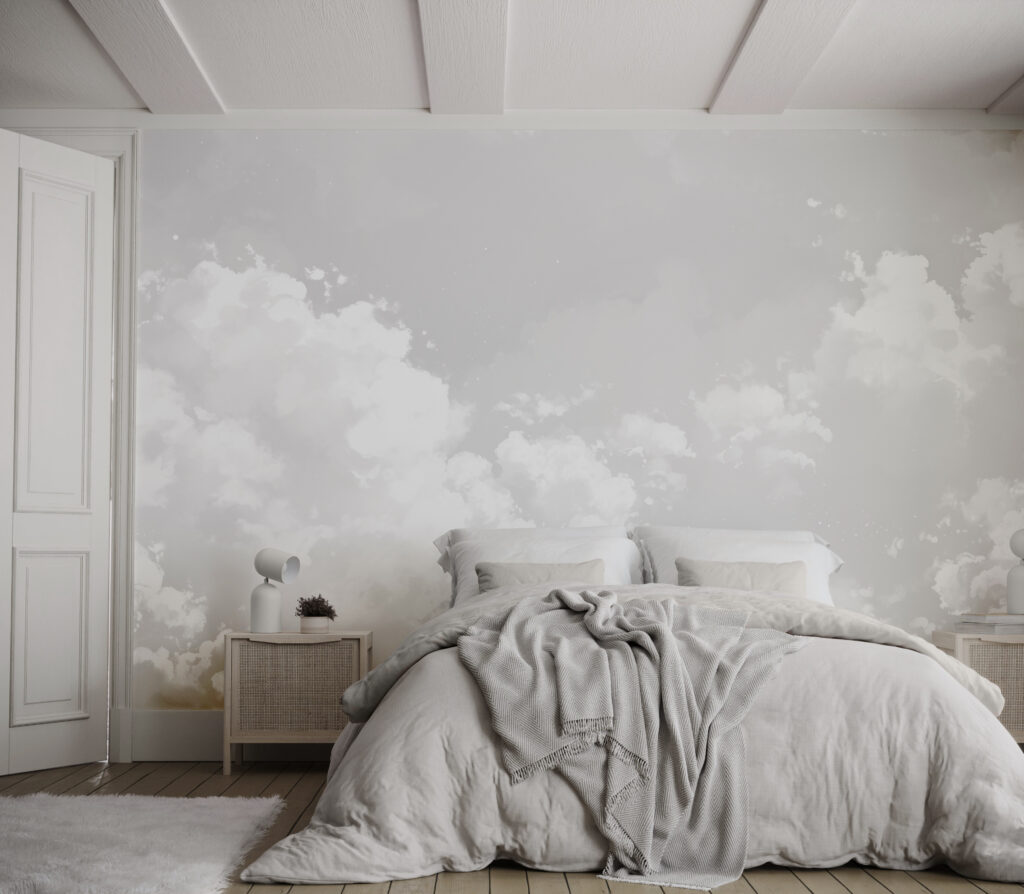 Beautiful cloud wallpaper behind a large bed with white an grey bedding