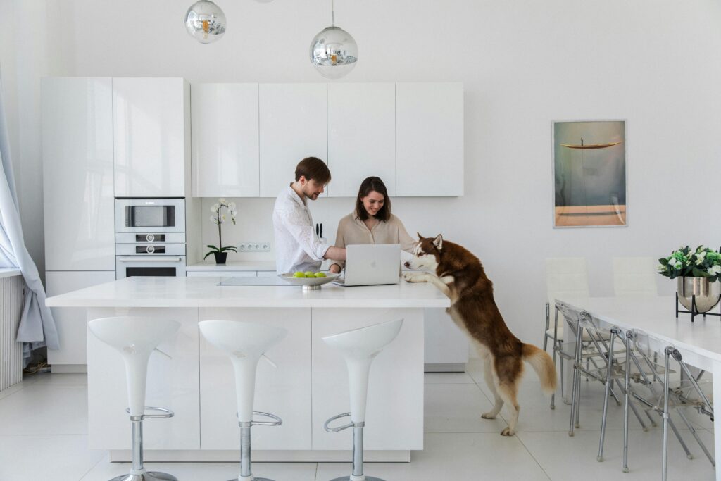 A bright white kitchen with a white island and white flooring