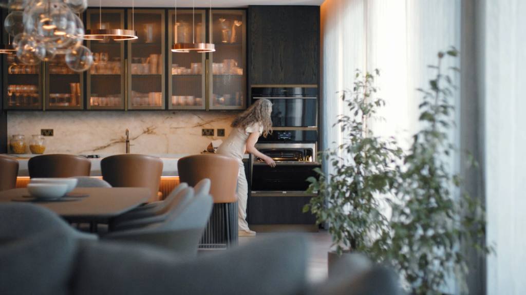 A dar brown kitchen with a large kitchen island that has lighter brown (mocha) bar stools