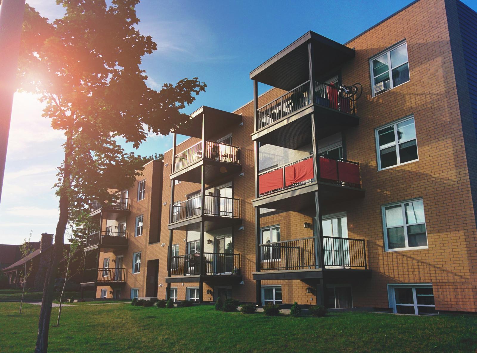 UK flat building with sun and blue skies behind